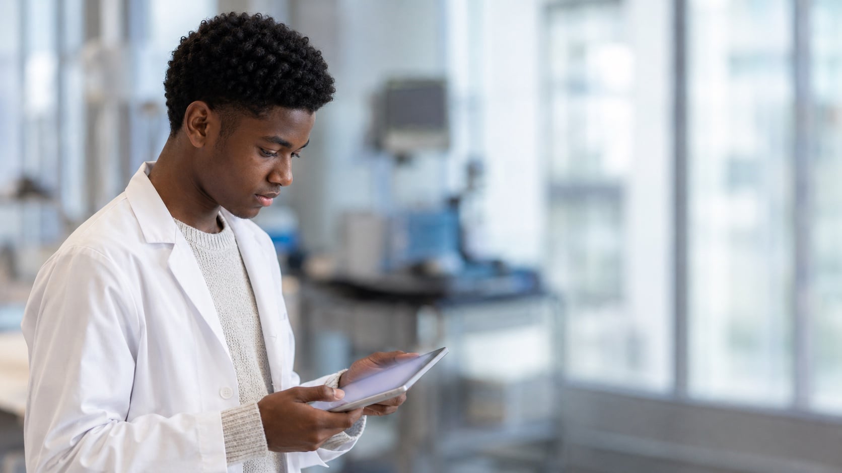 High school student in a clinical setting examining a tablet, working on a clinical-intake AI agent